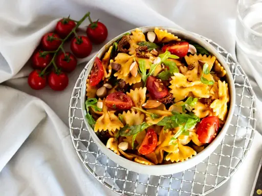 Mediterraner Salat mit getrockneten Tomaten und Rucola, garniert mit Mandeln und frischen Kirschtomaten. Ein leichter Genuss.