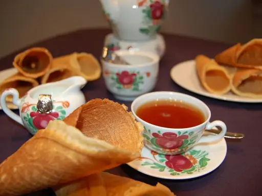 Omas Neujahrskuchen Rezept: knusprige Waffelröllchen mit Tee und Milch.