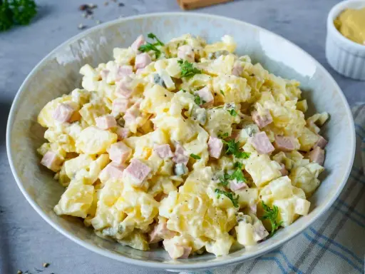 Omas Kartoffelsalat mit Mayonnaise, garniert mit Petersilie. Ein Klassiker, der immer schmeckt!