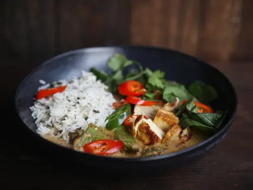 Ein köstliches Thai Curry Rezept mit Reis, gebratenem Tofu, Chili und frischen Kräutern in einer cremigen Sauce.