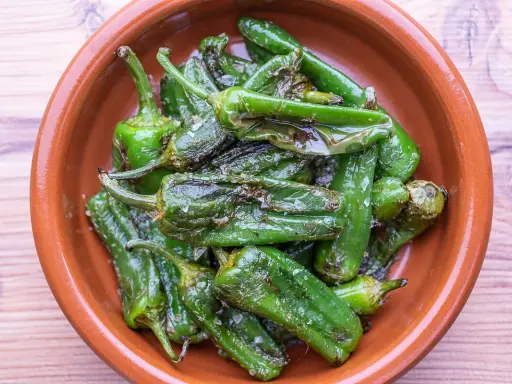 Gebratene Pimientos de Padrón in einer Tonschale, bereit für ein einfaches Rezept.