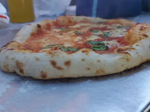 Frisch gebackene Pizza mit weltbestem Pizzateig mit Trockenhefe, belegt mit Tomaten, Mozzarella und Basilikum.