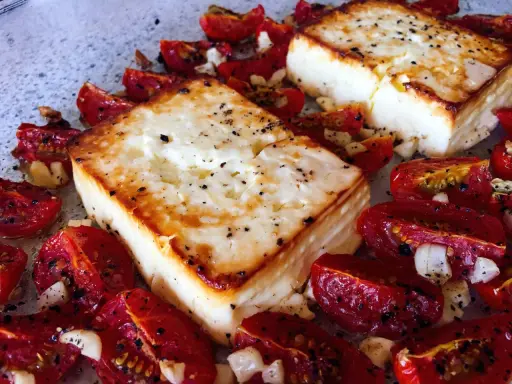 Ofen-gebackener Feta mit Kirschtomaten, Knoblauch und Kräutern. Ein köstliches griechisches Gericht, das im Ofen zubereitet wird.