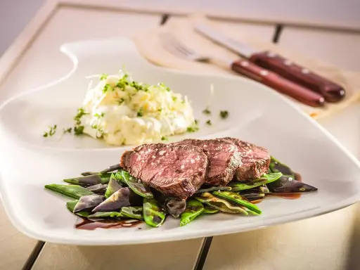 Sternekoch-Qualität: Zartes Kalbsfilet mit knackigen Zuckerschoten und cremigem Kartoffelsalat. Ein Genuss für jeden Gaumen.
