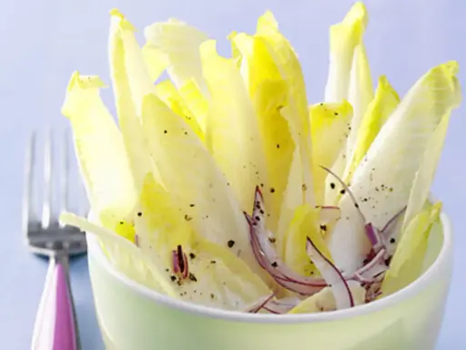 Frischer Chicorée Salat mit Orangen und roten Zwiebeln, gewürzt mit Pfeffer. Ein leichtes Gericht, das Lust auf mehr macht.