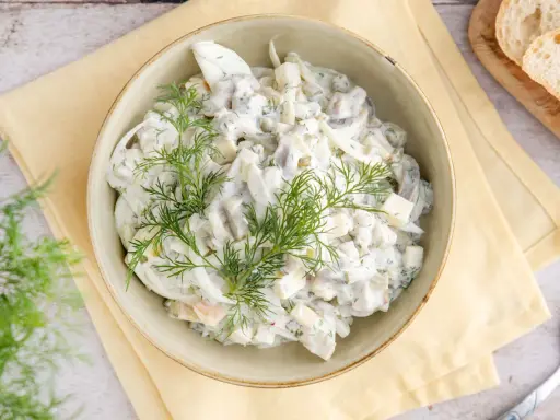 Hausfrauenart Heringssalat, ein cremiges Rezept wie von Oma, garniert mit frischem Dill.