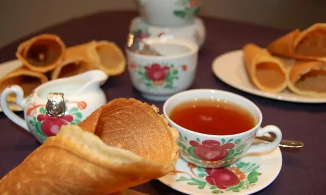 Omas Neujahrskuchen Rezept: knusprige Waffelröllchen mit Tee und Milch.