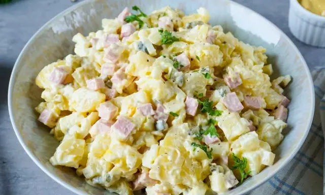 Omas Kartoffelsalat mit Mayonnaise, garniert mit Petersilie. Ein Klassiker, der immer schmeckt!