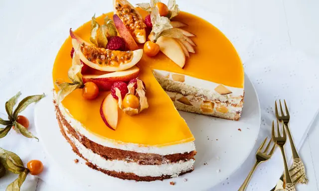 Eine köstliche Pfirsich Maracuja Torte, verziert mit frischen Früchten und Physalis. Ein süßer Genuss für besondere Momente.