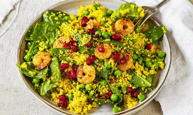 Bunter Couscous-Salat mit Garnelen, Erbsen, Spinat und Granatapfelkernen. Ein leichter und gesunder Genuss.