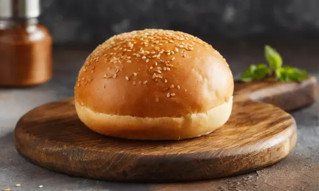 Ein goldbraunes Burgerbrötchen mit Sesam, bereit für das perfekte burger buns rezept.