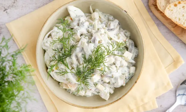 Hausfrauenart Heringssalat, ein cremiges Rezept wie von Oma, garniert mit frischem Dill.