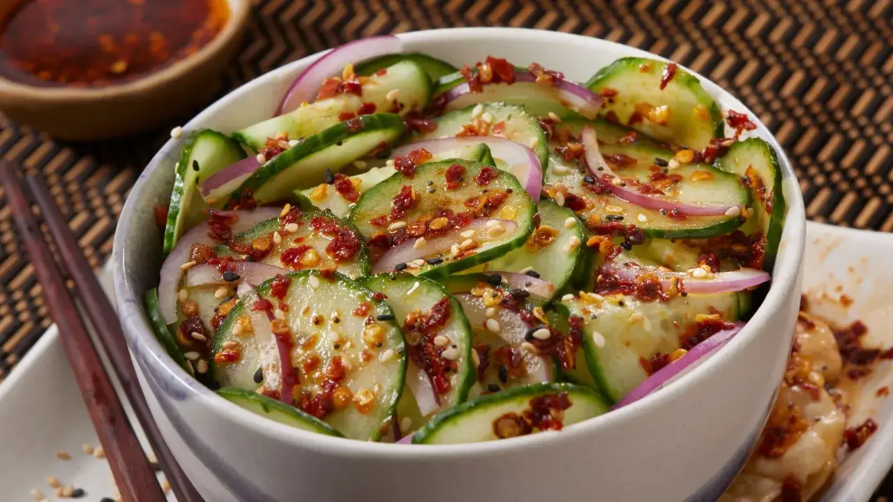Frischer asiatischer Gurkensalat mit roten Zwiebeln, Sesam und Chili-Flocken. Ein leichter und w&uuml;rziger Genuss.