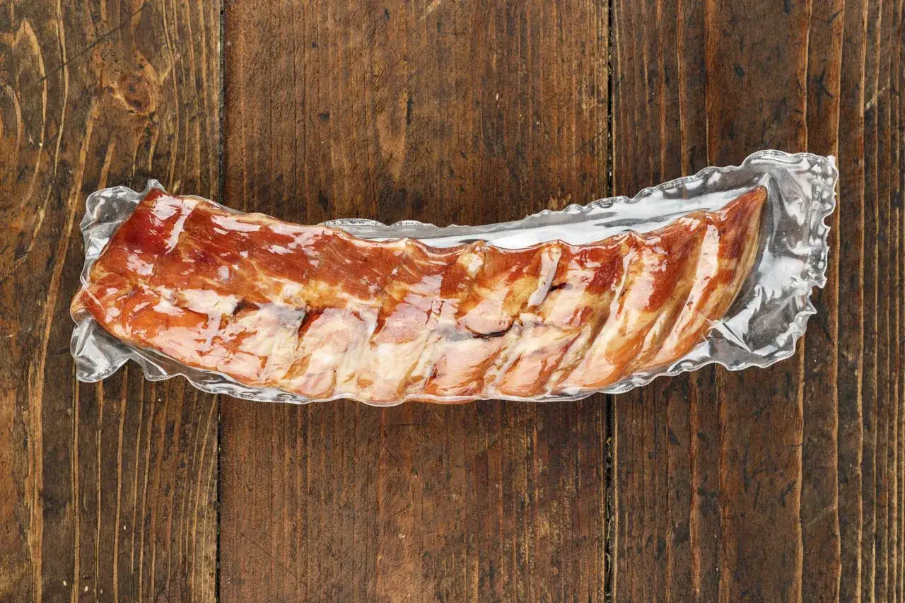 Vakuumverpackte Spareribs sous vide auf rustikalem Holz.