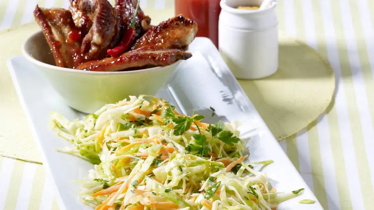 Saftige Spareribs mit einem frischen Krautsalat, garniert mit Petersilie. Ein perfektes Duo f&uuml;r den Sommer.