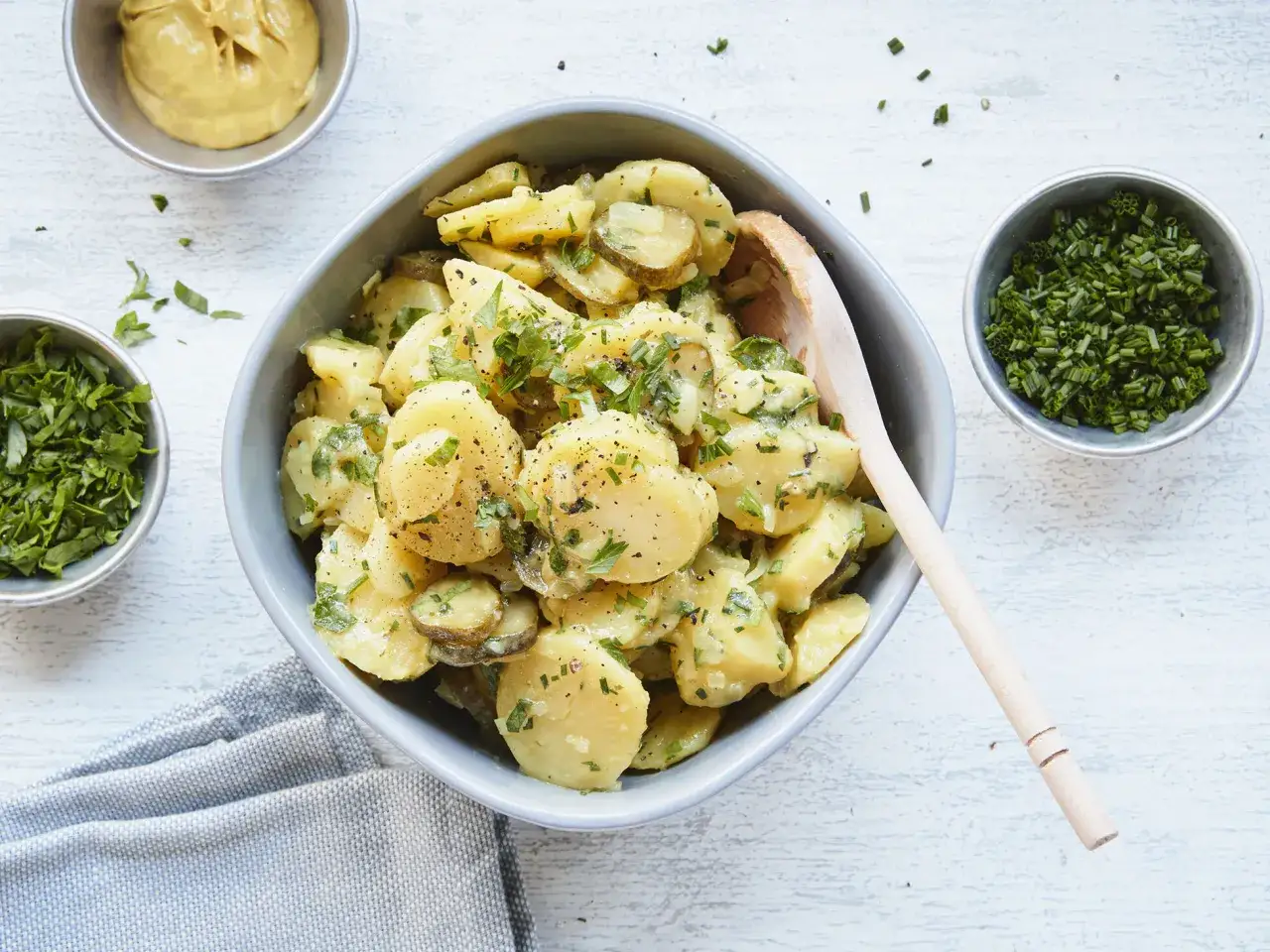 Kartoffelsalat ohne Mayo, mit frischer Petersilie und Schnittlauch, dazu Senf und Gewürzgurken.
