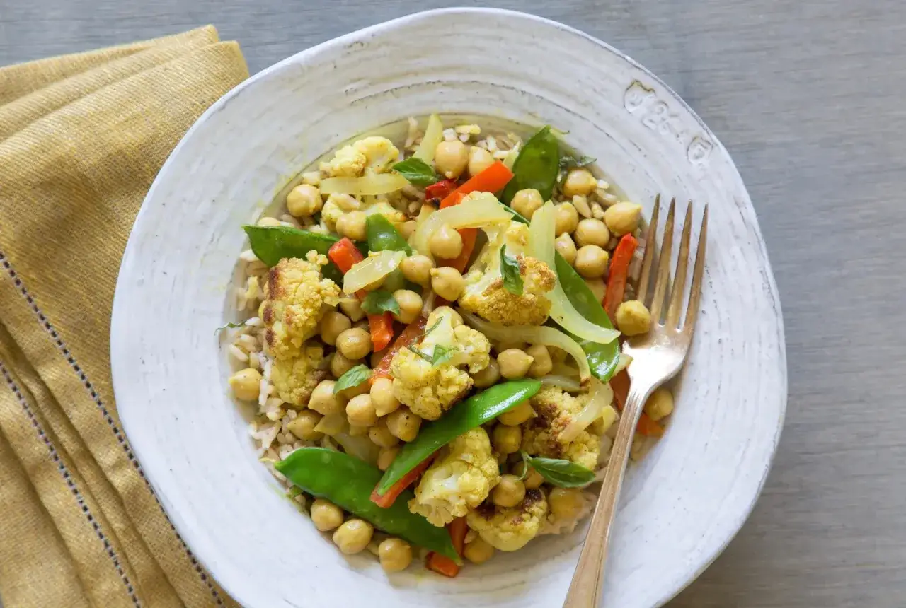 Ein k&ouml;stliches Thai Curry Rezept mit Blumenkohl, Kichererbsen und Erbsen auf Reis.