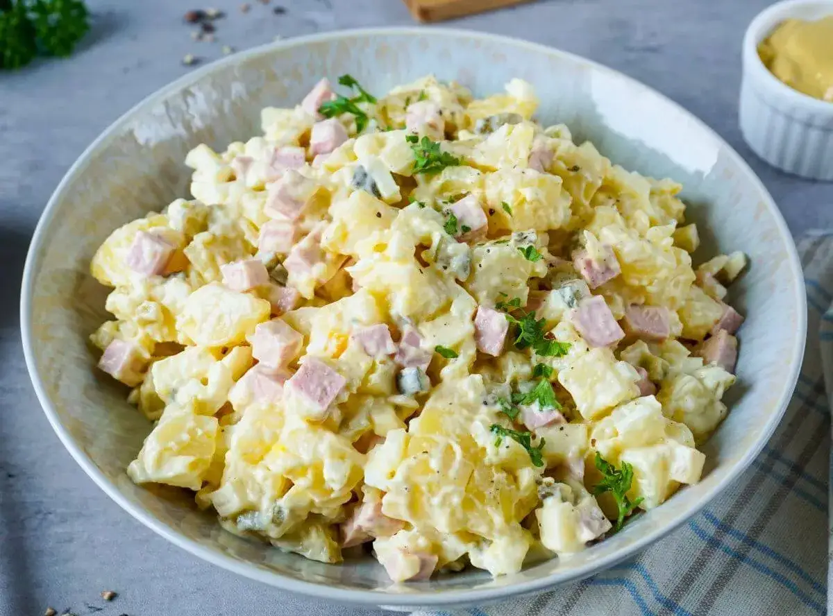 Omas Kartoffelsalat mit Mayonnaise, garniert mit Petersilie. Ein Klassiker, der immer schmeckt!