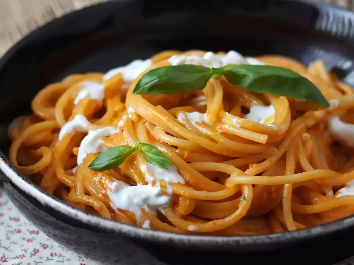 Spaghetti mit cremiger Tomatenso&szlig;e und Burrata. Ein einfaches Gericht, das zeigt, wie vielseitig Burrata Rezepte sein k&ouml;nnen. Garniert mit frischem Basilikum.