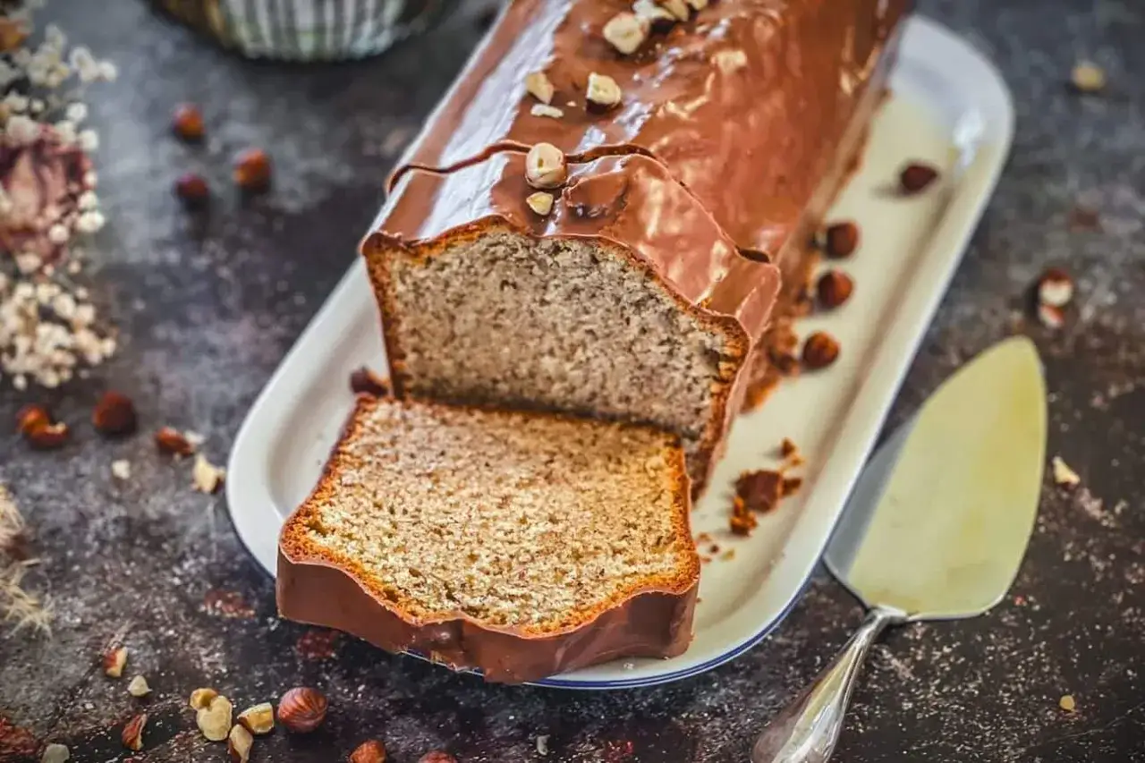 Schokoladen-Nusskuchen, ein Klassiker aus Omas besten Kuchen Rezepten, mit glänzender Glasur und gehackten Nüssen.