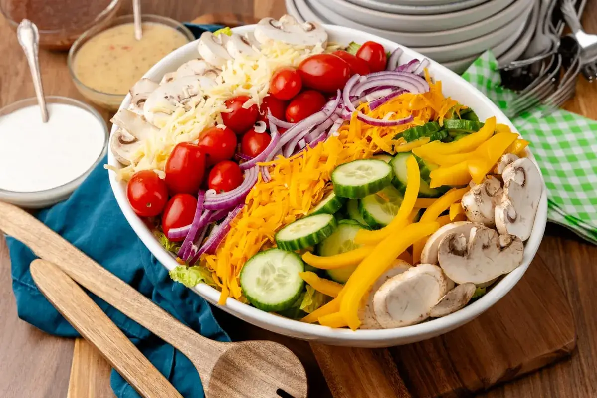Bunter Salat mit Tomaten, Gurken, Paprika, Zwiebeln, Pilzen und Käse – einer der 10 besten Salate für eine gesunde Mahlzeit.