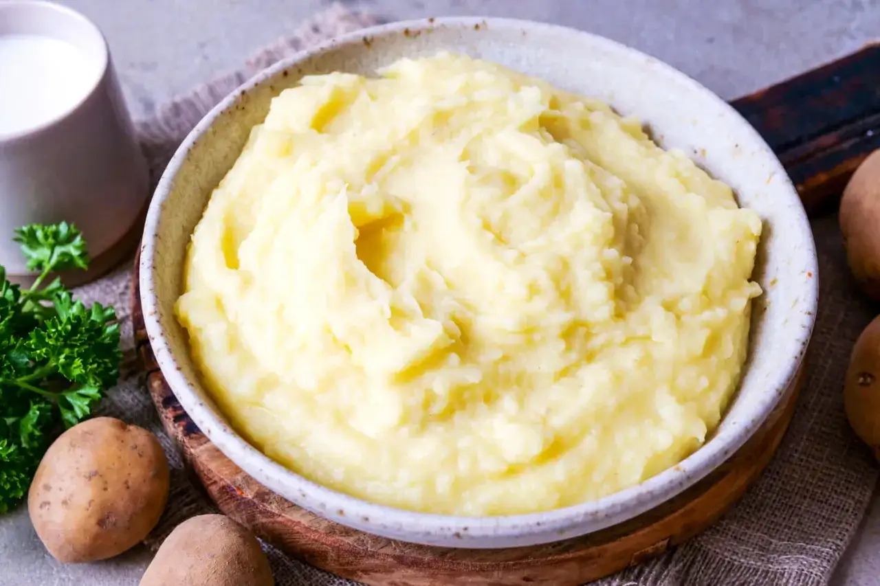 Cremiger Kartoffelbrei, perfekt f&uuml;r jedes Kartoffelbrei Rezept. Dazu frische Petersilie und rohe Kartoffeln.